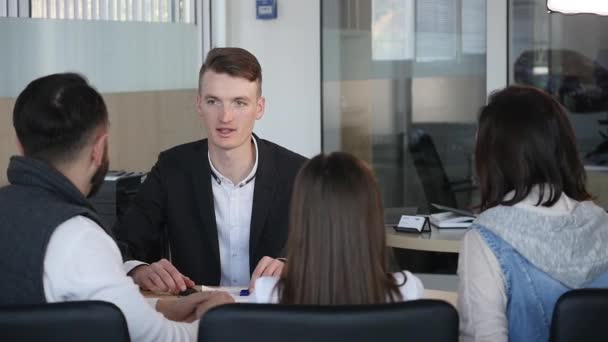 Sprzedawca samochodów przekazujący kluczyki do nowego samochodu — Wideo stockowe