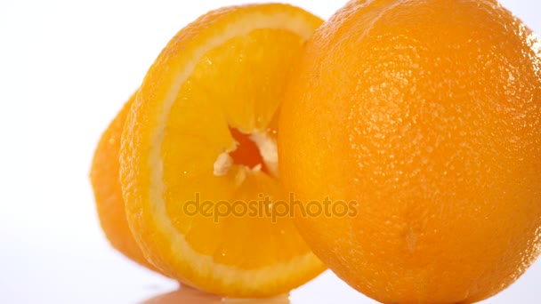 Πορτοκαλί με το μισό του πορτοκαλί απομονωμένο στο λευκό φόντο — Αρχείο Βίντεο
