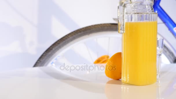 Rotação de suco de laranja e laranja na bicicleta de mesa no fundo — Vídeo de Stock