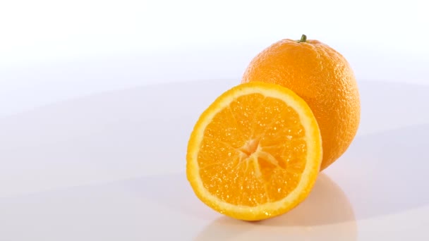 Tranches d'orange tournant sur blanc — Video