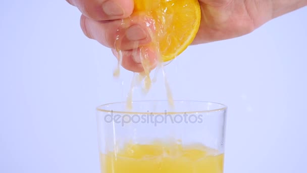 Чоловіча рука стискає свіжий апельсиновий сік. Рука стискає апельсин. Повільний рух 96 к/с — стокове відео