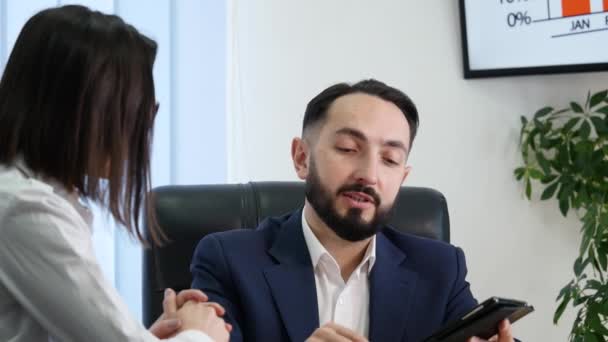 Деловой человек объясняет что-то женщине с цифровым планшетом в офисе — стоковое видео