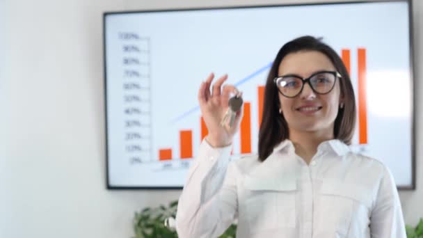 Mujer de negocios sonriente sosteniendo un llavero — Vídeo de stock