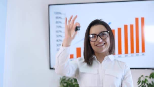 Mujer de negocios sonriente sosteniendo un fondo gráfico llavero — Vídeos de Stock