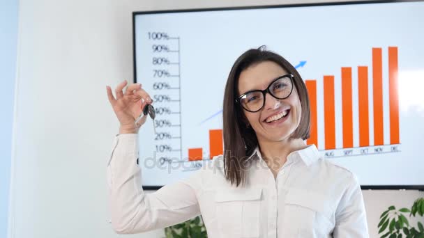 Mujer de negocios sonriente sosteniendo un fondo gráfico llavero — Vídeo de stock