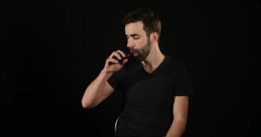 Genç vaping elektronik sigara ile adam ve bazı mavi duman bulutları olun