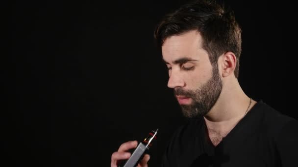 Uomo vaporizzare una sigaretta elettronica.Isolato su sfondo nero — Video Stock