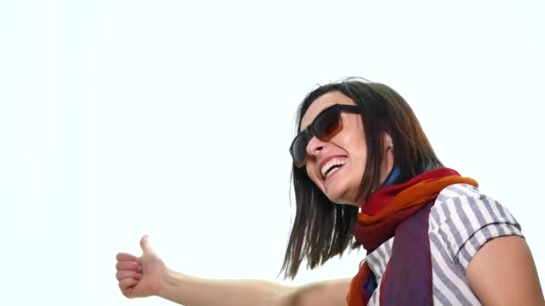 Lächelnde, lässige Frau zeigt vereinzelt mit dem Finger auf weißem Hintergrund weg — Stockvideo