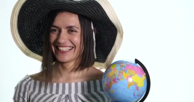 giovane donna filando un globo, decidere dove andare in vacanza
