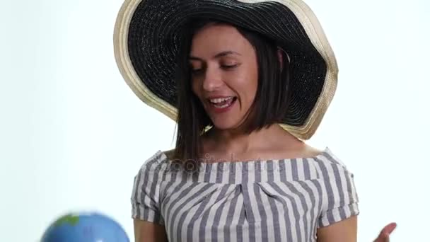 Mulher sorridente bonita apontando para o globo onde quer ir — Vídeo de Stock