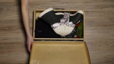 Bavulun içinde pasaport ellerini. Harita ve pasaport dökmeyin. Tatil sezonu. Kadın uçuş için hazır hale getirilir