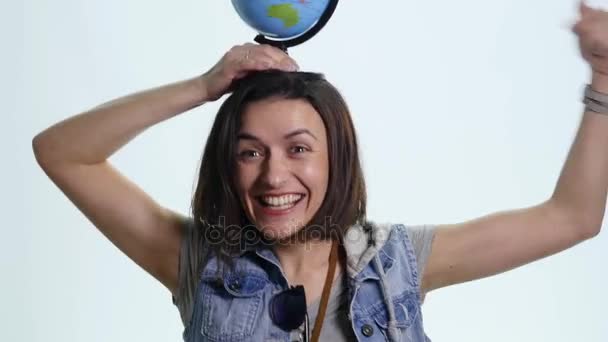 Portret van mooie jonge vrouw met globe in handen tegen witte achtergrond — Stockvideo