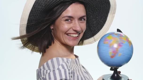 Mujer sosteniendo y apuntando al globo sobre fondo blanco — Vídeos de Stock