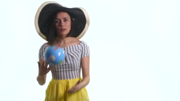 Una giovane ragazza sorridente sta indicando un globo su uno sfondo bianco — Video Stock