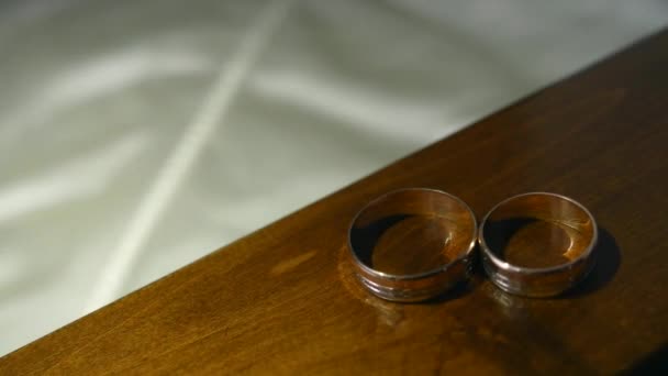 Anillos de boda en la mesa, luz — Vídeo de stock