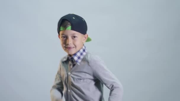 En pojke med ett tandlöst leende dansar en paus med händerna — Stockvideo