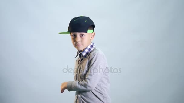The boy turns sharply on white background and shows class — Stock Video