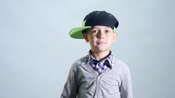 Хлопчик в шапці витирає ніс рукавом — стокове відео