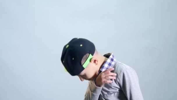 Kluk v čepici utírá nos s rukávu a skok — Stock video