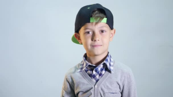 El chico con una gorra parpadea un ojo — Vídeos de Stock