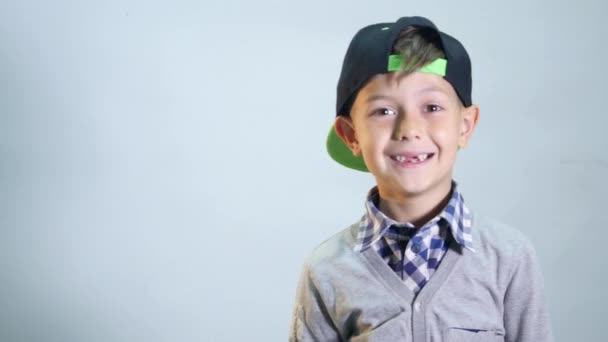 O menino com sorriso sem dentes ri forte no fundo branco — Vídeo de Stock