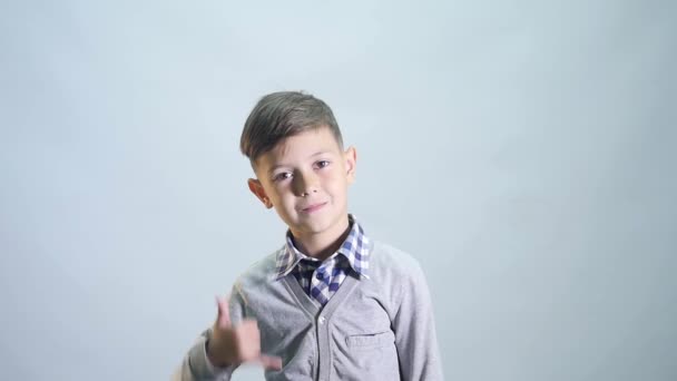 Маленький хлопчик робить виклику мене жест і підморгує — стокове відео