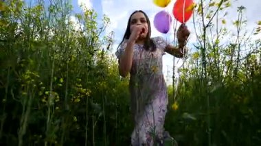 elinde sarı buğday alan balonları aracılığıyla çalışan elbiseli küçük kız. yavaş hareketleri