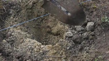 Ön plan ve arka plan bulanık bir toprak kazma bir adam toprağa kürek sıkışmış