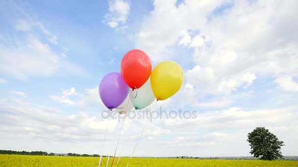 Цветные воздушные шары на фоне голубого неба — стоковое видео