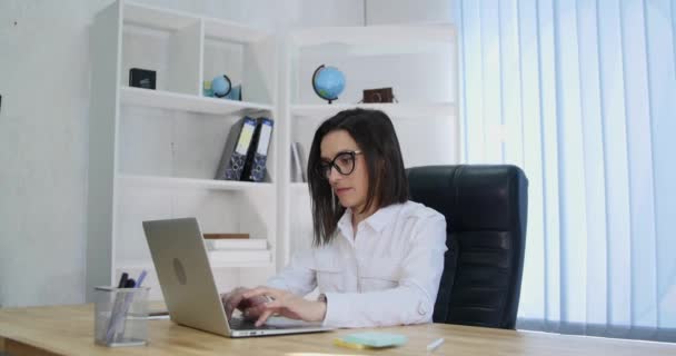 Exitosa mujer de negocios que trabaja con el ordenador portátil en la oficina — Vídeos de Stock