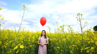 Mutlu küçük kız yolda gün anda oynamak. O alanında ayakta ve holding eller bavul ve balonlar. Çocuk doğa üzerinde eğleniyor. Mutluluk kavramı