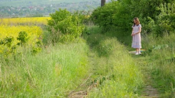 A child runs through a meadow with a kite — Stock Video