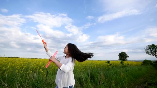 Šťastná holčička hraje mezi mýdlové bubliny na zelené louce v létě — Stock video