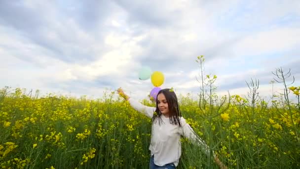 Menina feliz brincando com bolhas de sabão, balões no prado, criança sorridente Relaxante no campo de estupro, câmera lenta — Vídeo de Stock