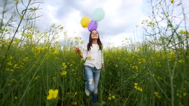 Gelukkig jong meisje lopen met ballonnen in tarweveld — Stockvideo