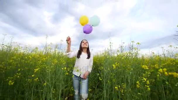 Szczęśliwa młoda dziewczyna spaceru z balonami w polu pszenicy — Wideo stockowe