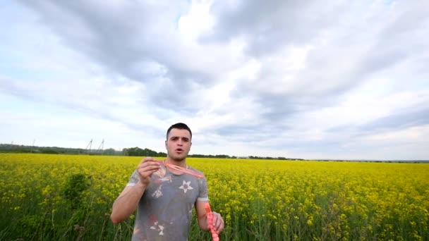 Jeune homme jouant avec des bulles de savon — Video