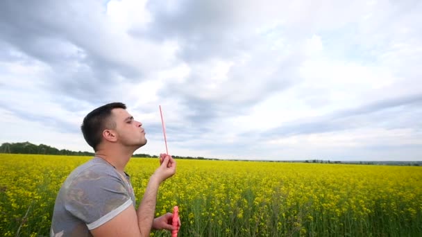 Mladý muž si hraje s mýdlové bubliny — Stock video