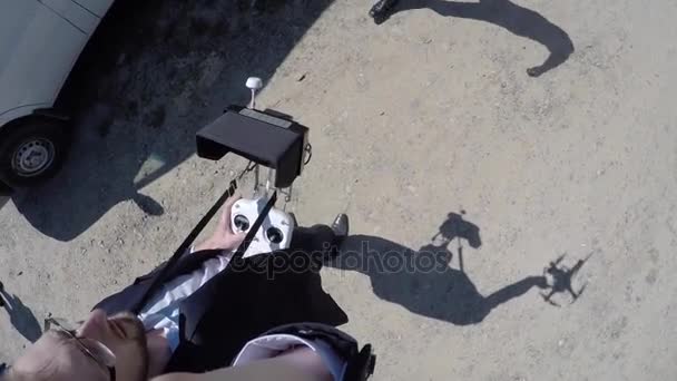 Drone aterrissando na rua Operador de drone aterrissando um drone em uma esquina de rua em um céu azul claro contra o sol, e depois se afastando com seu drone — Vídeo de Stock