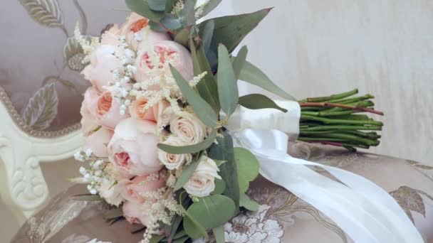 Beau bouquet de mariage avec des fleurs roses allongées sur la chaise dans la chambre — Video