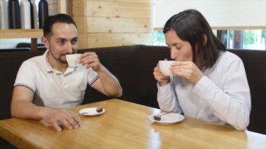 Kahve içen çift kafede gülüyor.