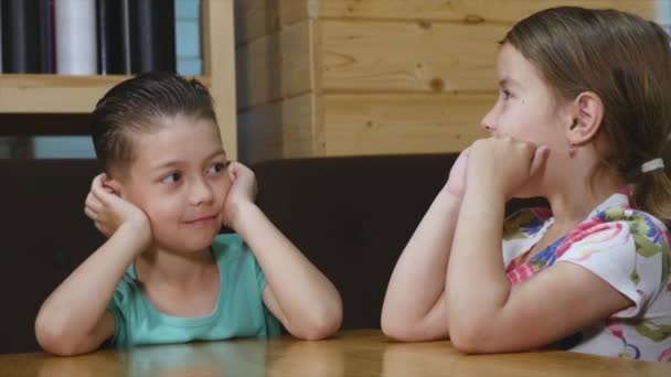 Niño pequeño con una chica hablando en la cafetería — Vídeos de Stock