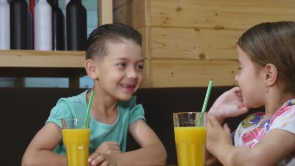 Niños bebiendo jugo en una cafetería — Vídeo de stock