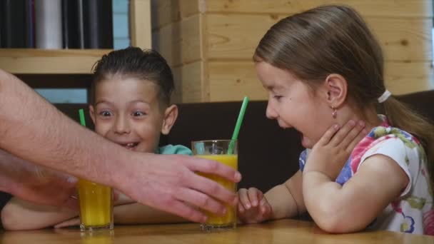 Niños bebiendo jugo en una cafetería — Vídeo de stock