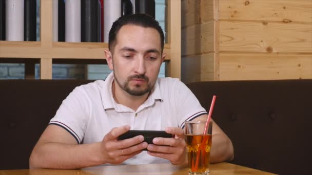 Az ember ül, és használ smartphone a kávézóban — Stock videók