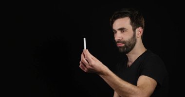 adam siyah arka plan üzerinde elektronik veya normal sigara arasında karar vermek