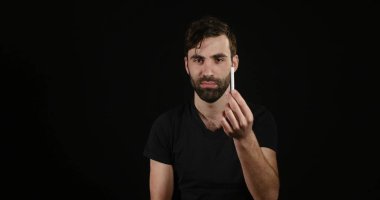 adam siyah arka plan üzerinde elektronik veya normal sigara arasında karar vermek