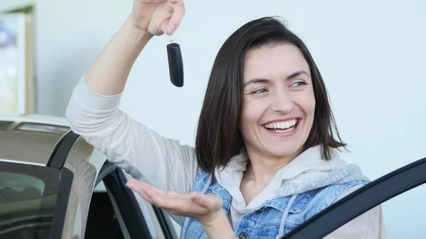 Mulher feliz motorista mostrando chaves do carro e inclinando-se na porta do carro — Fotografia de Stock