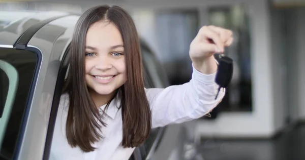 행복 한 아기 소녀는 그의 새로운 자동차의 키를 보여주는. 자동차 사업, 자동차 판매, 기술 및 사람들 개념-자동 표시 또는 살롱에 자동차 딜러와 함께 행복 한 남자. 젊은 남자는 모터쇼에서 세일즈 맨으로 — 스톡 사진
