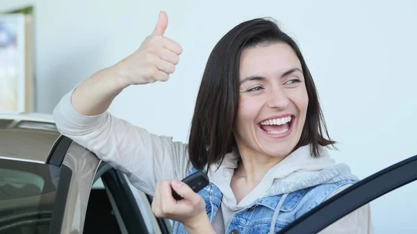 Mulher feliz motorista mostrando chaves do carro e inclinando-se na porta do carro — Fotografia de Stock